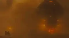 Two figures watching a giant skull in the fog
