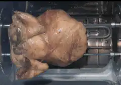 Whole chicken roasting on rotisserie