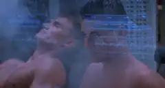 Two shirtless men in a steamy room with holographic display