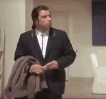 John Travolta holding coat and shrugging