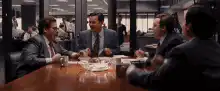 Men in suits clinking glasses in a diner
