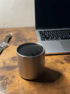 Coffee cup on desk next to laptop