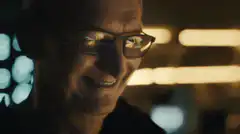 Tim Cook smiling with phone reflection