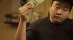 Ken Jeong holding a dollar bill