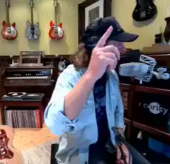 Man in studio laughs and points