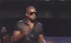 Kanye West shrugging on stage