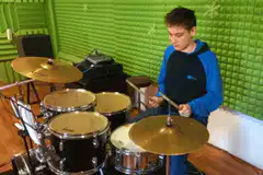 boy playing drums in green room