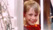 Macaulay Culkin smiling and waving