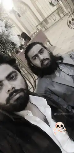 Two men with beards posing in a decorated room
