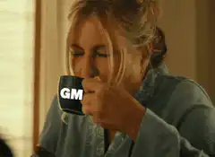 Woman drinking coffee with GM mug and laser eyes