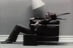 man relaxing in chair with scarf blowing