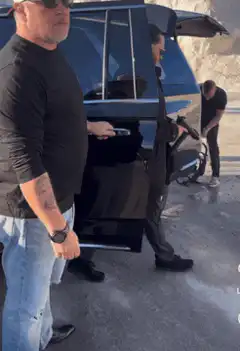 John Wick exits black SUV with gun