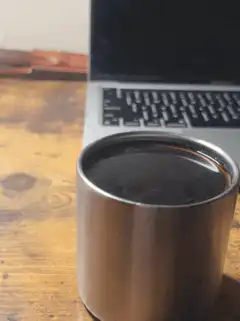 coffee cup on desk near laptop