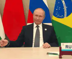 Vladimir Putin raises mug for toast