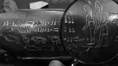 Magnifying glass over ancient cuneiform tablet