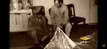 Two men examining a UFO wing
