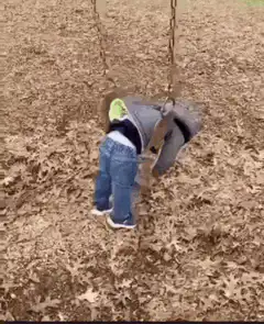 Toddler swinging upside down in leaves