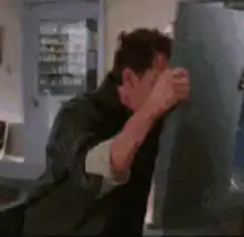 man pushes fridge door shut on woman