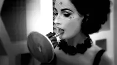 Dita Von Teese applying lipstick