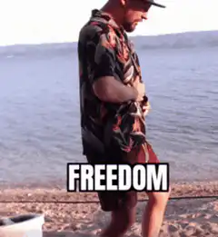 Man throws off shirt on beach