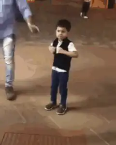Little boy takes off vest and dances