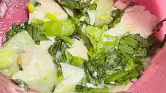 pink bowl with cooked greens and fish