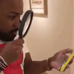 Man examining phone with magnifying glass