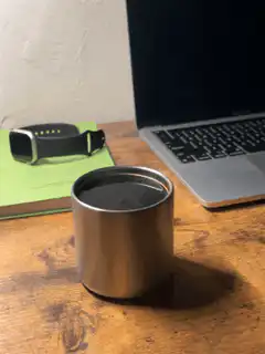Metal cup on desk with laptop