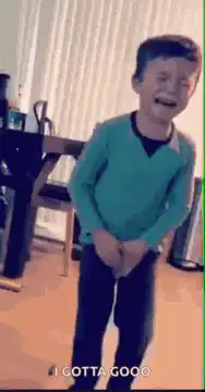 Boy laughing holding crotch