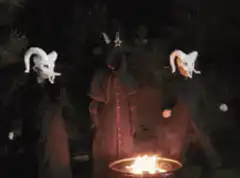 Three figures dancing around a fire