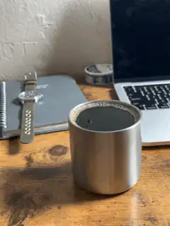 Steam rising from a metal cup of coffee