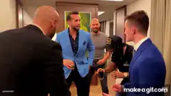 Men in suits laughing in a hallway