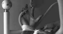 Hand tied to bedpost with gag