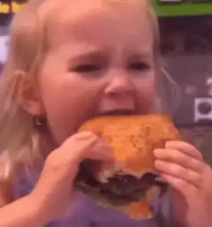 Little girl eating burger and falling asleep