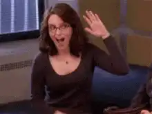 Woman waving excitedly then smiling