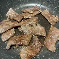 sliced beef cooking in pan