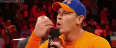 John Cena raises hand with microphone