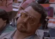 John Goodman squinting in a classroom