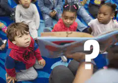 Boy in Spiderman shirt confused by book
