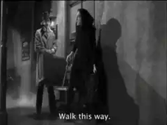Woman walks past man with cane