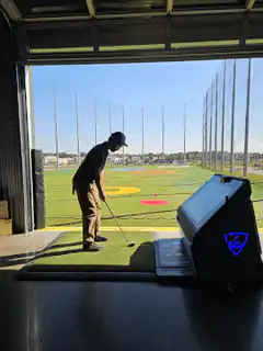 Man practicing golf swing at driving range