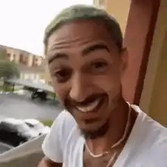 Man with green hair laughing and pointing
