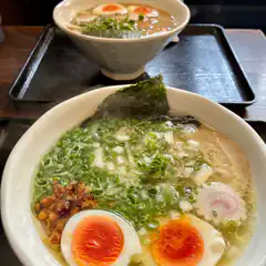 Two bowls of ramen with eggs and green onions