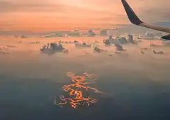 Sunset reflection on water from airplane window