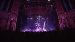 Band performing on stage with heart logo