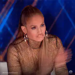 Jennifer Lopez clapping with a skeptical look