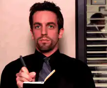 B.J. Novak writing and looking up