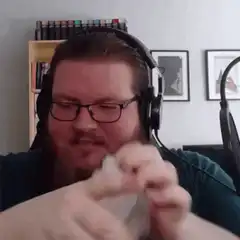 Man with headphones and beard cracking knuckles