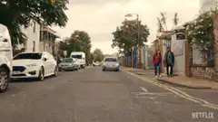 Masked bikers ride down a street