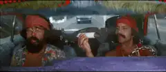 Two men in a car with a large gun
